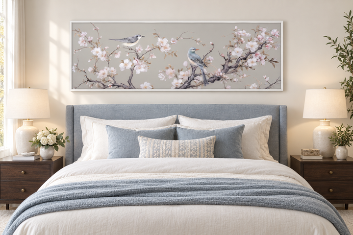 Horizontal framed canvas wall art featuring two birds on blossoming branches above a bed.