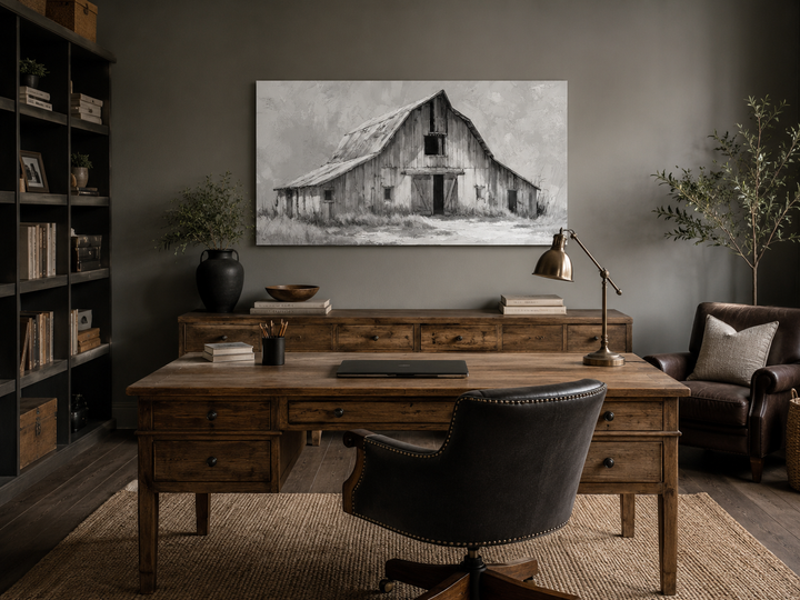 Black and white barn canvas wall art hanging in a rustic home office with a wooden desk.