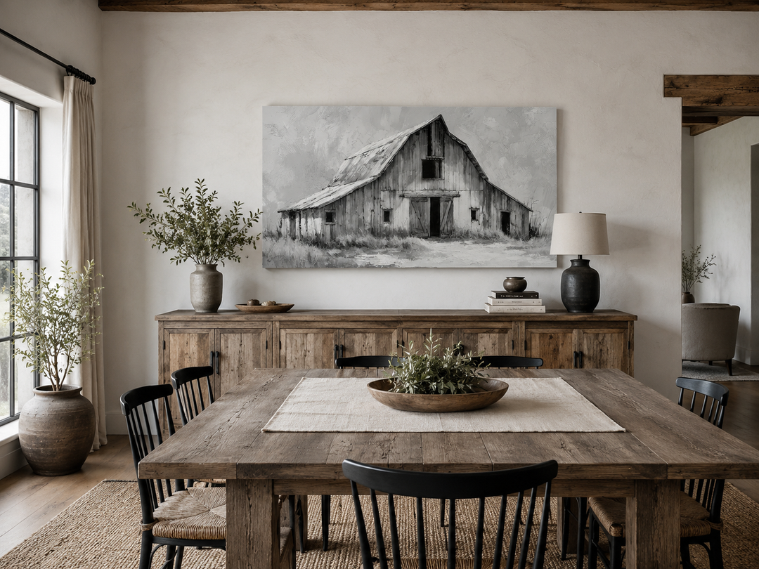 Black and white barn canvas print hanging above a rustic wooden sideboard in a farmhouse dining room.