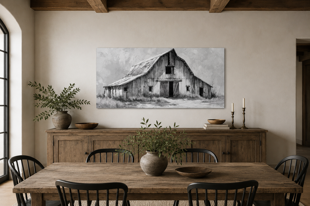 Black and white barn canvas print hanging above a rustic wooden sideboard in a farmhouse dining room.