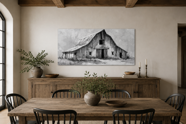 Black and white barn canvas print hanging above a rustic wooden sideboard in a farmhouse dining room.
