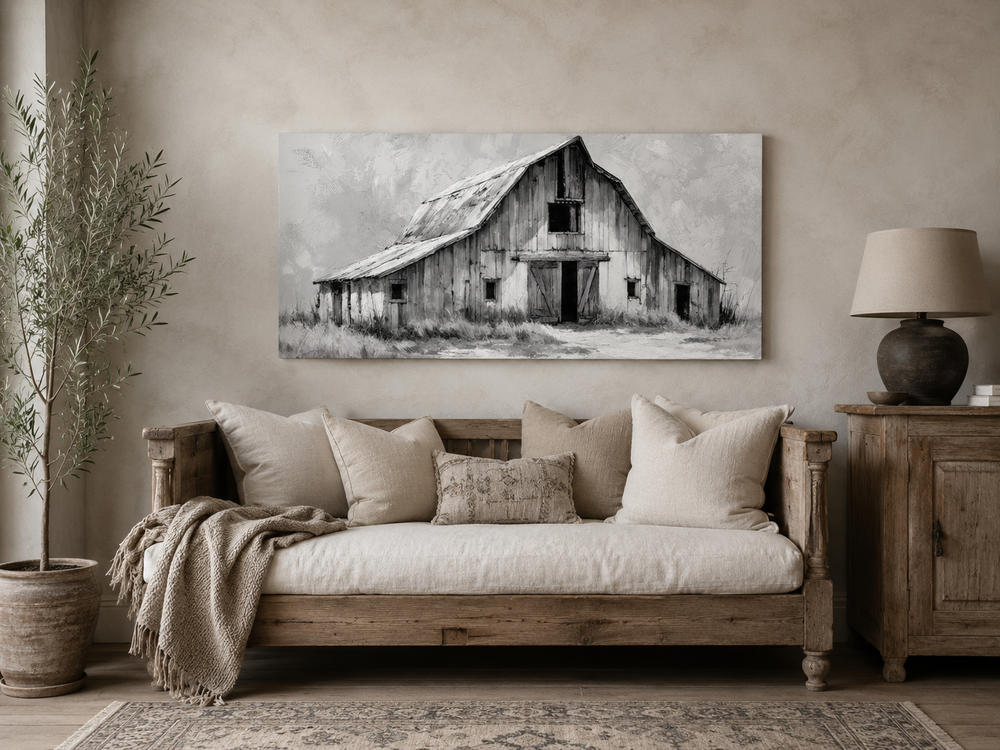 Black and white barn canvas print above a rustic wooden sofa with neutral pillows and a throw.