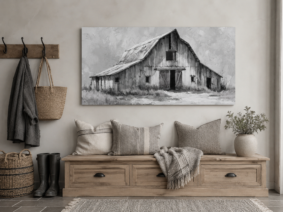 Black and white barn canvas print hanging above a rustic wooden bench with pillows and a throw.
