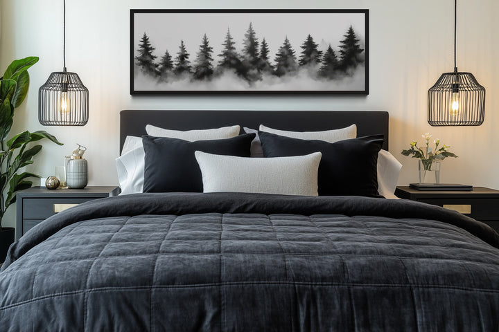 Black and white watercolor foggy pine tree forest horizontal canvas wall art above a bed.