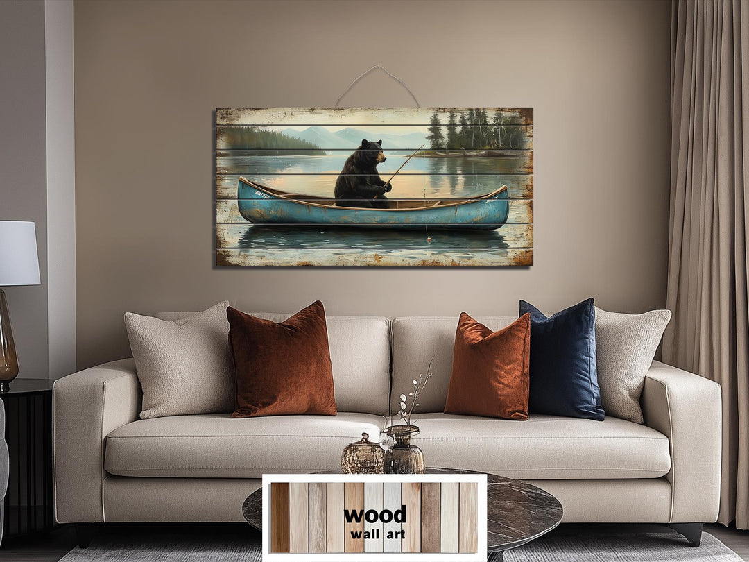 Black bear fishing in a blue canoe on distressed wood wall art hanging above a modern sofa.