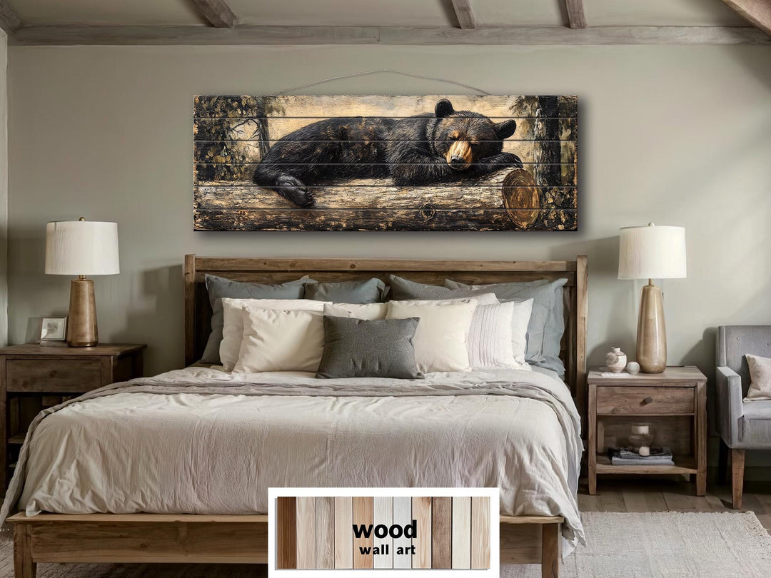 Horizontal wood wall art featuring a black bear sleeping on a log in a rustic bedroom setting.