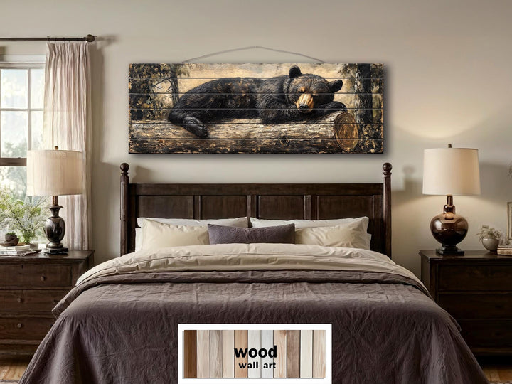 Rustic wood wall art featuring a black bear sleeping on a log, hung above a bed in a cozy bedroom.