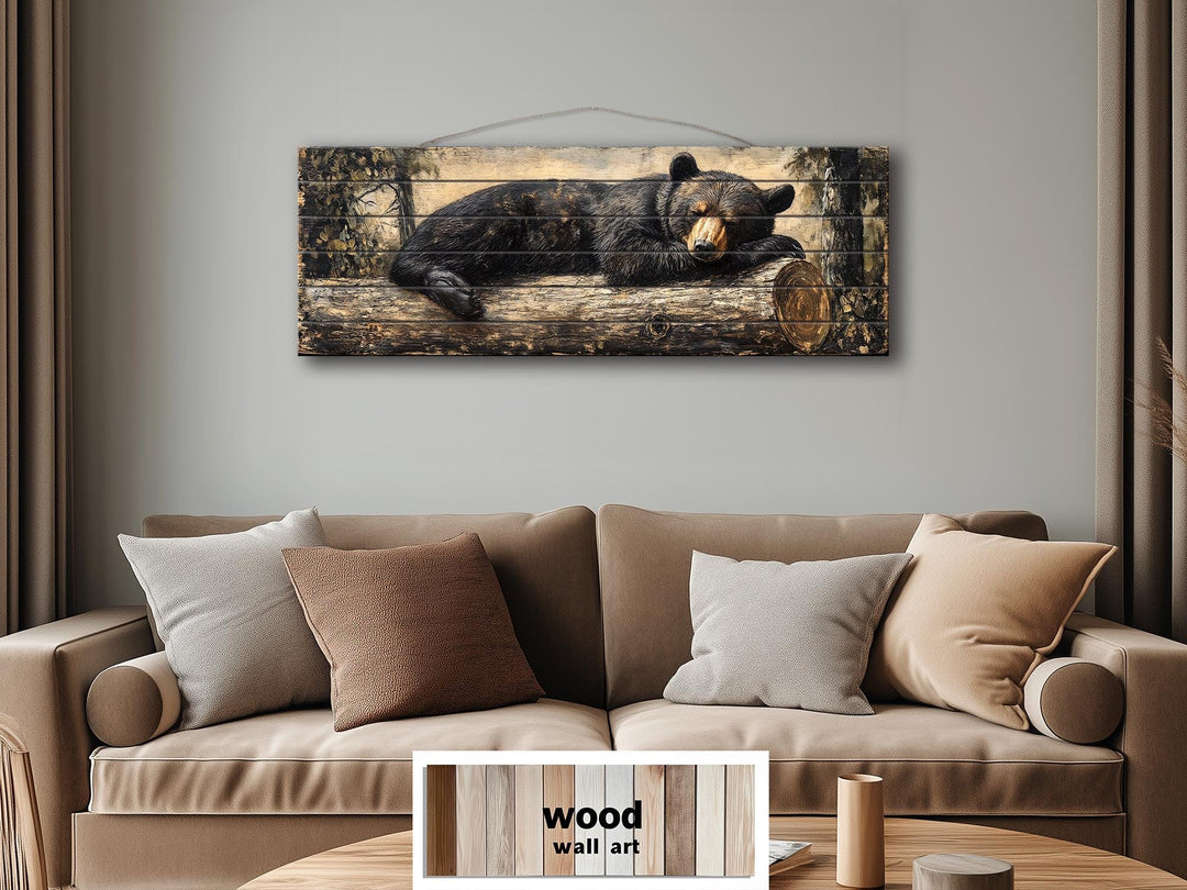 Horizontal wood wall art featuring a black bear sleeping on a log above a tan sofa.