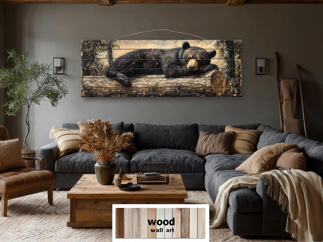 Horizontal wood wall art featuring a sleeping black bear on a log in a rustic living room.