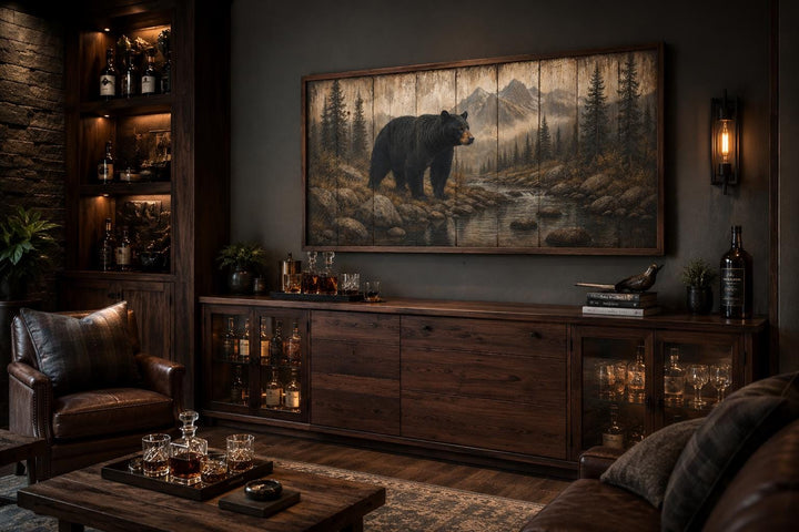 Rustic black bear canvas print wall art in a mountain forest scene above a dark wood sideboard.