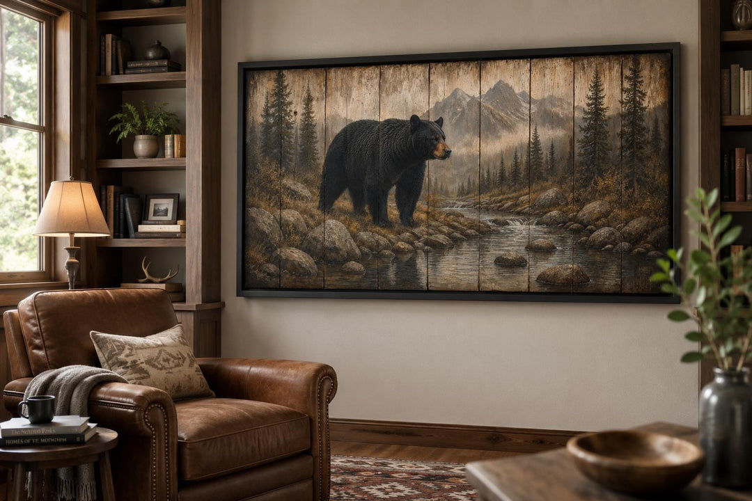 Rustic black bear canvas print in a mountain lodge setting with leather chair and wood bookshelves.