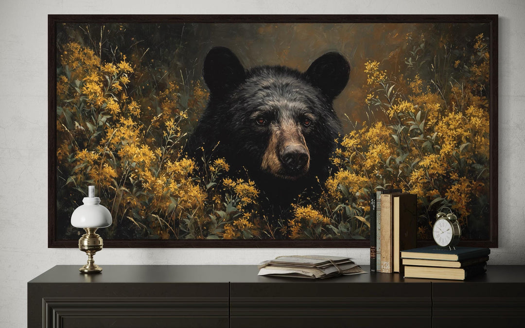 Black bear canvas wall art featuring a bear in golden wildflowers, framed above a dark console.