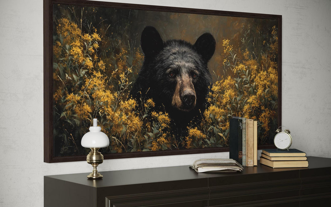 Black bear canvas wall art featuring a bear in yellow wildflowers, displayed above a dark dresser.