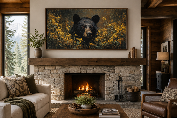 Black bear in yellow wildflowers canvas wall art hanging above a stone fireplace in a rustic cabin.