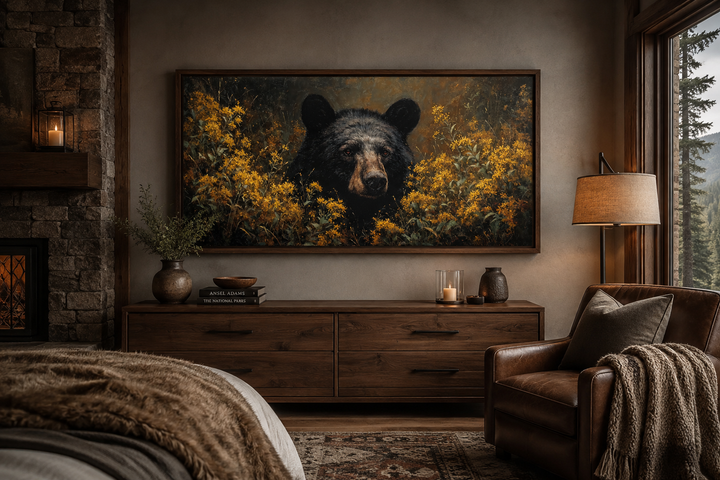 Black bear canvas wall art in a wooden frame above a dresser in a rustic cabin bedroom.