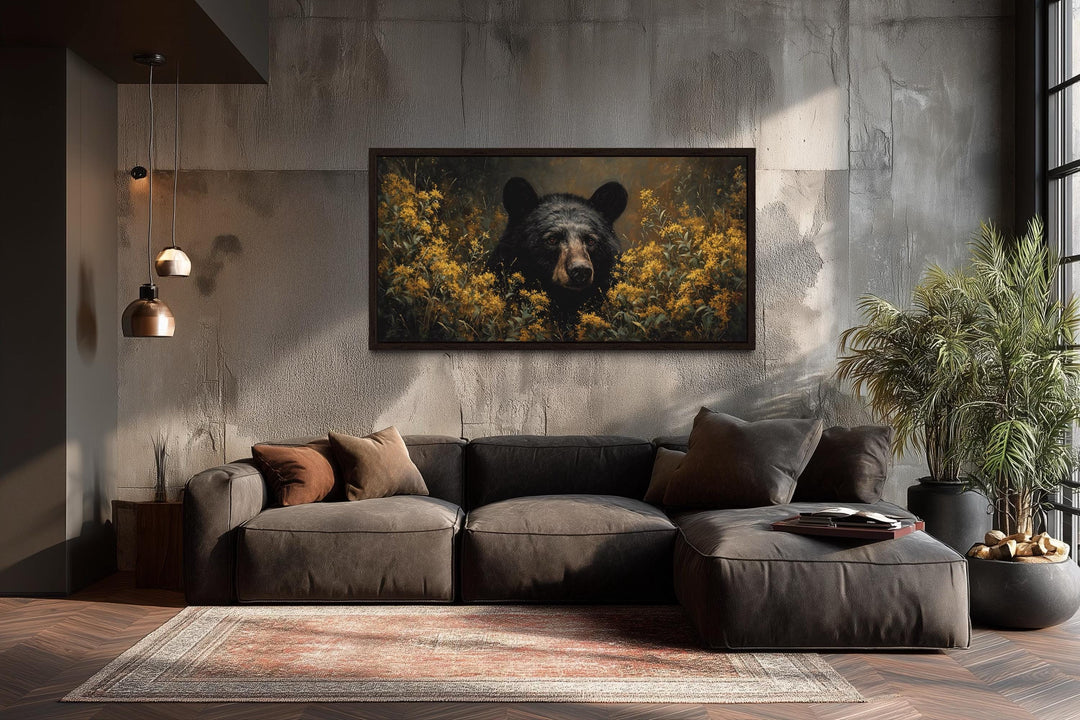 Black bear in yellow wildflowers canvas wall art hanging above a modern sofa in a rustic room.