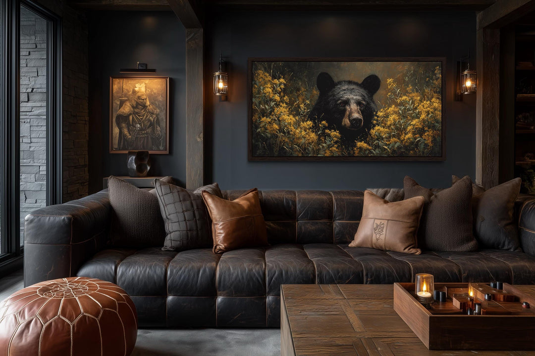 Black bear canvas wall art featuring a bear in yellow wildflowers above a leather sofa.