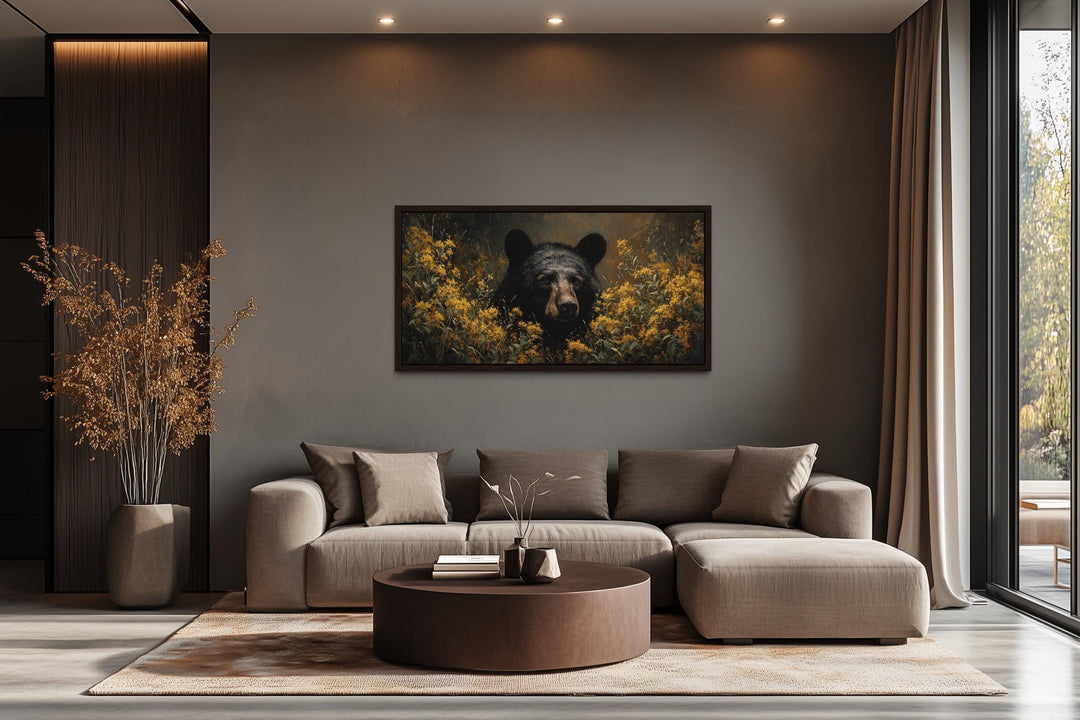 Black bear in yellow wildflowers canvas wall art hanging above a modern sofa in a living room.