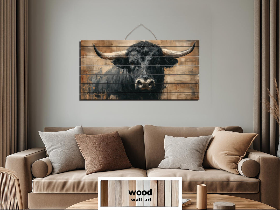 Black bull portrait printed on horizontal wood planks, rustic western wall art for a living room.