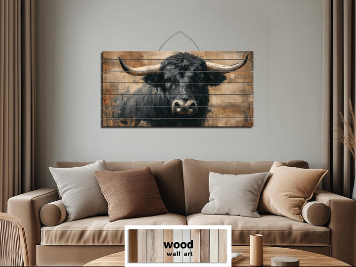 Black bull portrait printed on horizontal wood planks, rustic western wall art for a living room.