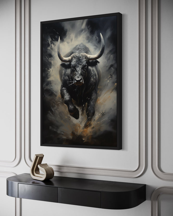 Black charging bull abstract framed canvas wall art on a white paneled wall above a black console.