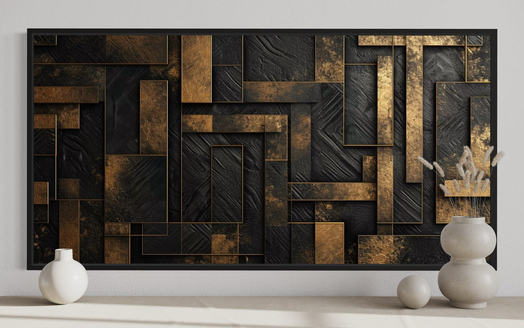 Black and gold abstract geometric framed canvas wall art displayed above a shelf with vases.