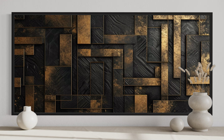 Black and gold abstract geometric framed canvas wall art displayed above a shelf with vases.