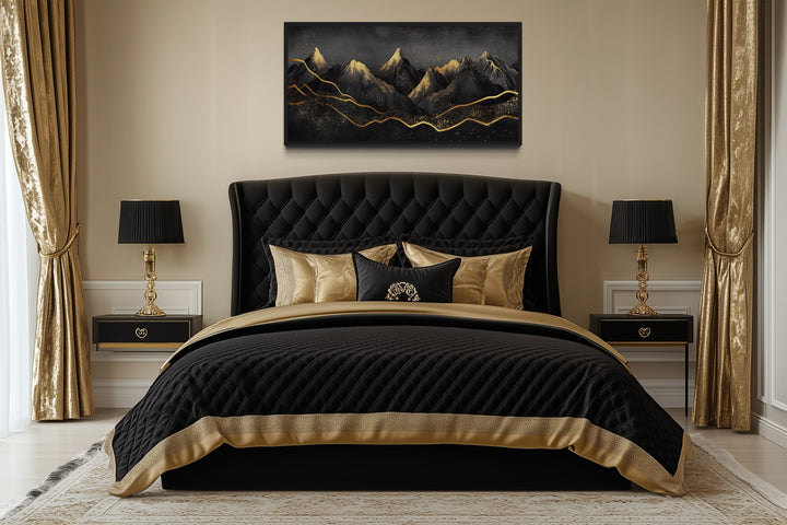 Black and gold abstract mountain framed canvas wall art hanging above a black tufted bed.