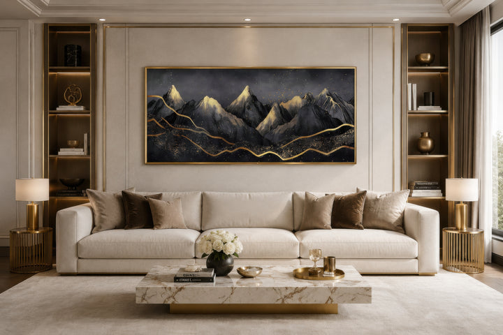 Black gold abstract mountain framed canvas wall art hanging above a white sofa in a living room.