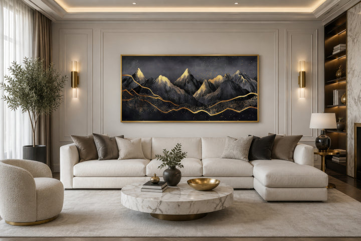 Black gold abstract mountain framed canvas wall art hanging above a white sectional sofa.