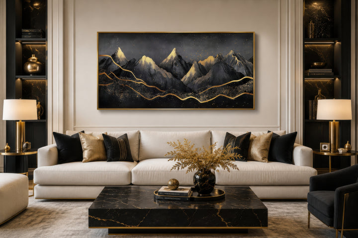 Black gold abstract mountain framed canvas wall art hanging above a white sofa in a living room.