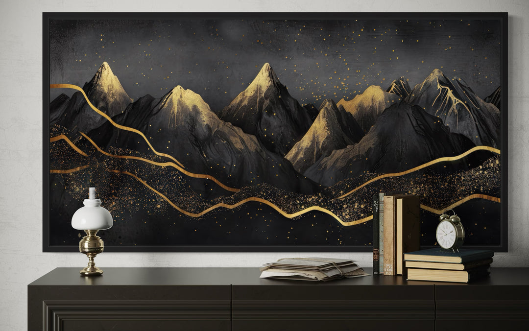 Black and gold abstract mountain framed canvas wall art displayed above a dark wooden sideboard.
