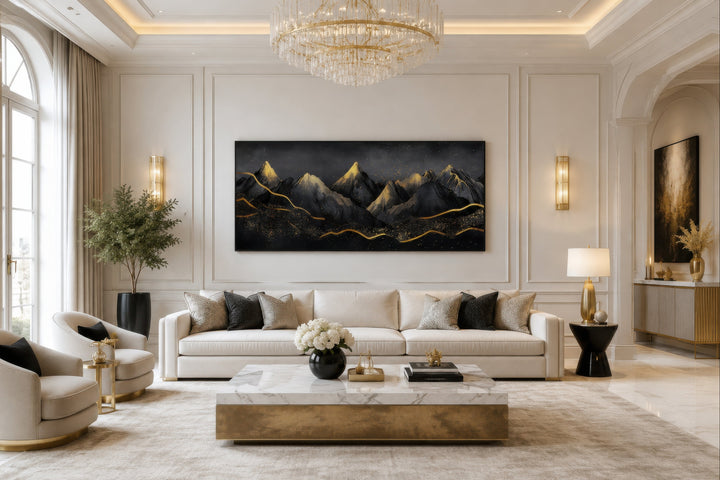 Black gold abstract mountain framed canvas wall art hanging above a white sofa in a living room.