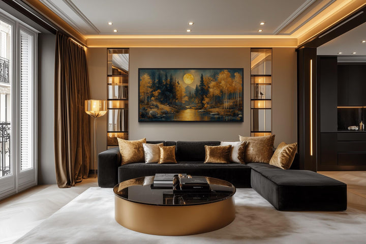 Black gold art nouveau trees and moon landscape framed canvas wall art above a black sofa.