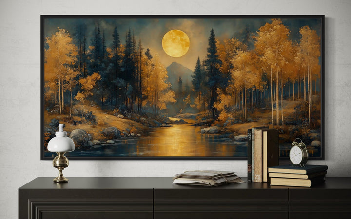 Black gold Art Nouveau framed canvas art of a moonlit forest landscape over a dark sideboard.