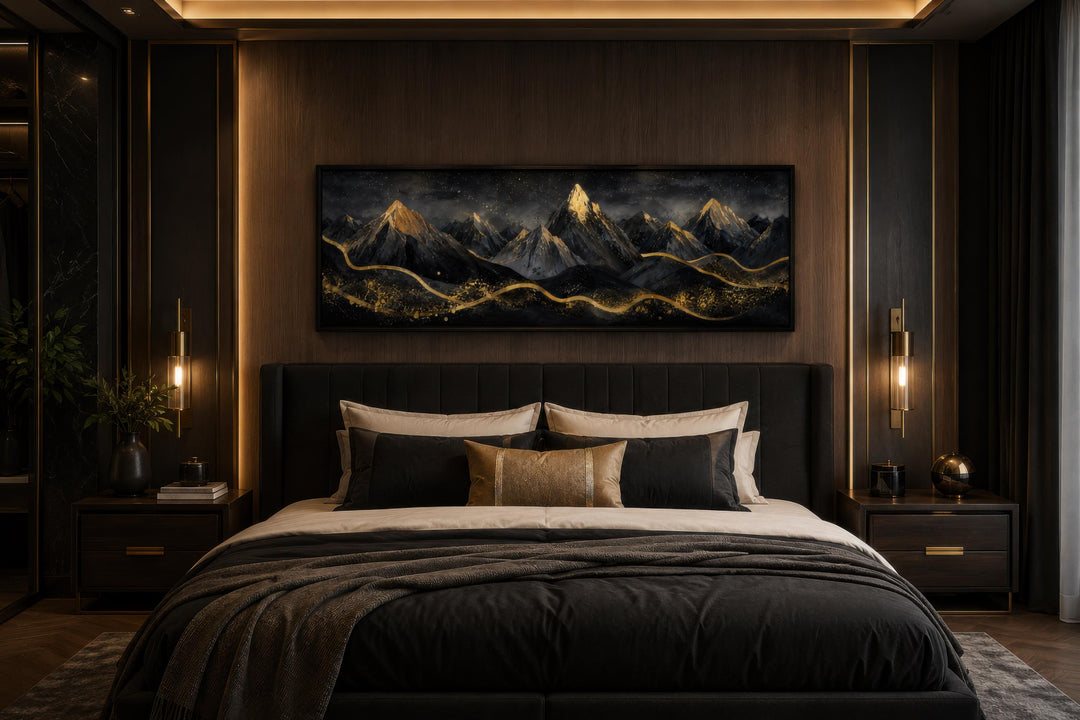 Long narrow canvas wall art featuring black mountains with gold accents above a dark bedroom headboard