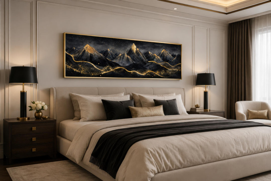 Long narrow canvas of black and gold mountains hanging above a bed in a modern bedroom.