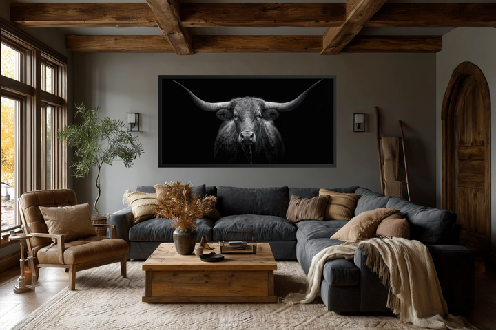 Extra large black and white canvas wall art of a Texas Longhorn cow centered above a living room sofa.