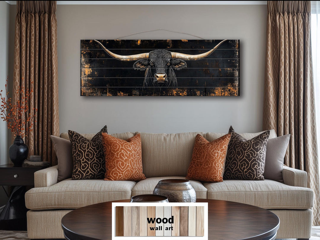 Black Texas Longhorn long horizontal wood wall art hanging above a tan sofa in a living room.