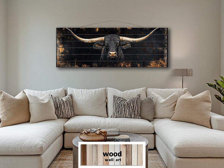 Black Texas Longhorn printed on horizontal rustic wood planks hanging above a neutral sofa.