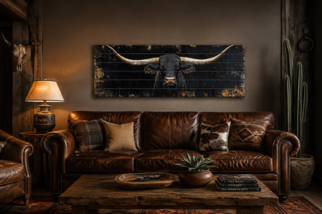 Black Texas Longhorn printed on horizontal rustic wood planks above a leather sofa.