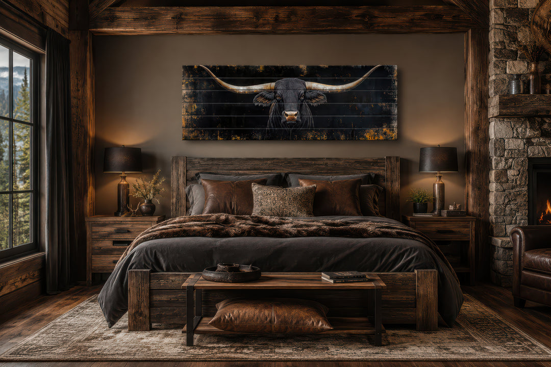 Black Texas Longhorn long narrow real wood wall art hanging above a bed in a rustic bedroom.
