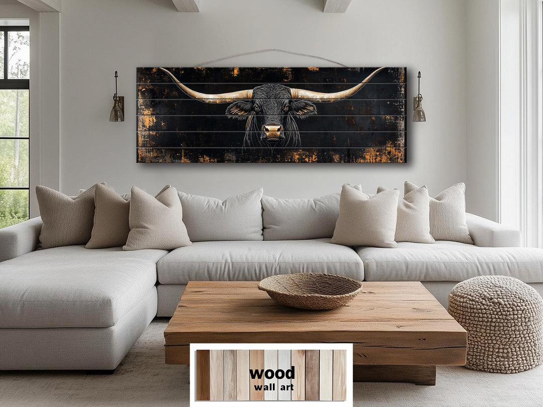 Black Texas Longhorn printed on horizontal wood planks, hanging above a sofa in a rustic room.
