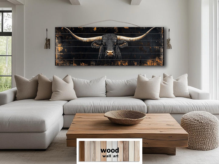 Black Texas Longhorn printed on horizontal wood planks, hanging above a sofa in a rustic room.