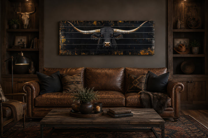 Black Texas Longhorn printed on horizontal wooden planks above a brown leather sofa.