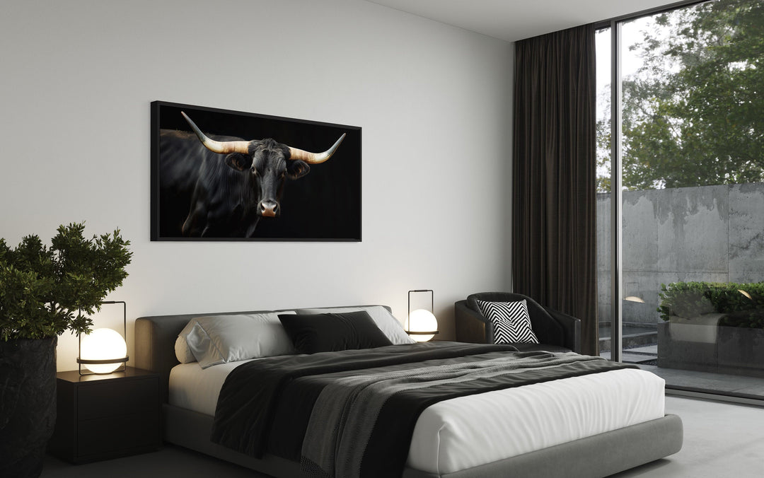 Extra large framed canvas print of a black Texas Longhorn bull hanging above a modern bed.