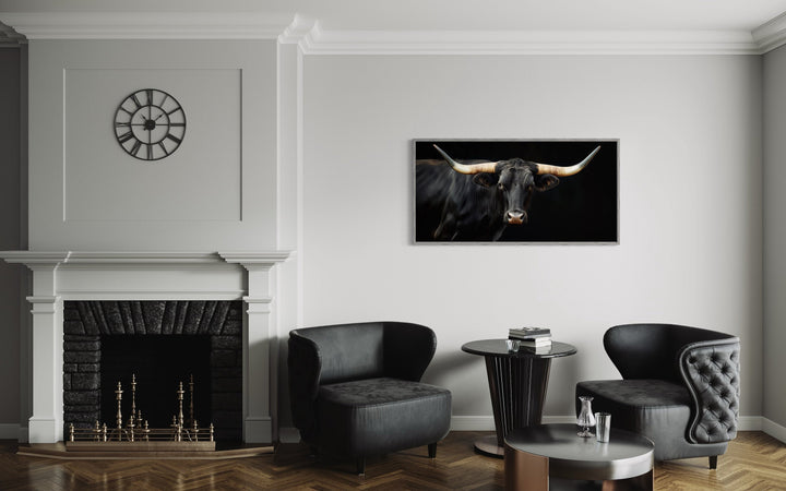 Extra large framed canvas print of a black Texas Longhorn bull hanging above a modern seating area.