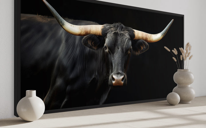 Extra large framed canvas print of a black Texas Longhorn bull against a dark background.