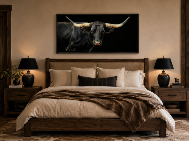Extra large framed canvas print of a black Texas Longhorn bull above a rustic wooden bed.