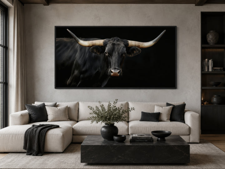 Extra large framed canvas print of a black Texas Longhorn bull above a modern sofa.